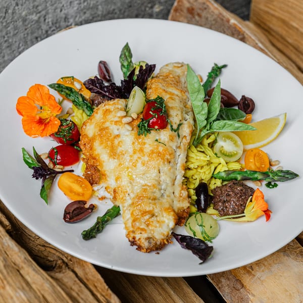 Notch 8's pan-seared fish with orzo, asparagus, tomatoes, olives, and edible flowers.