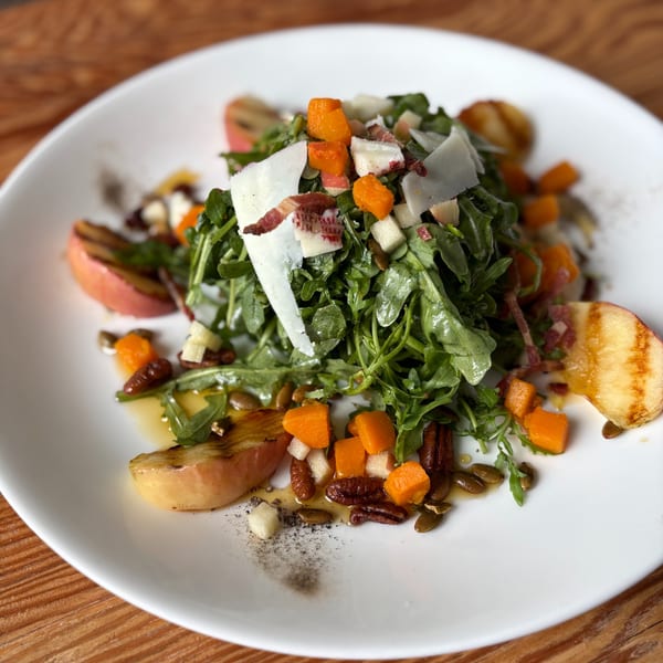 Notch 8's American cuisine: a vibrant salad with arugula, butternut squash, apples, pecans, and parmesan.